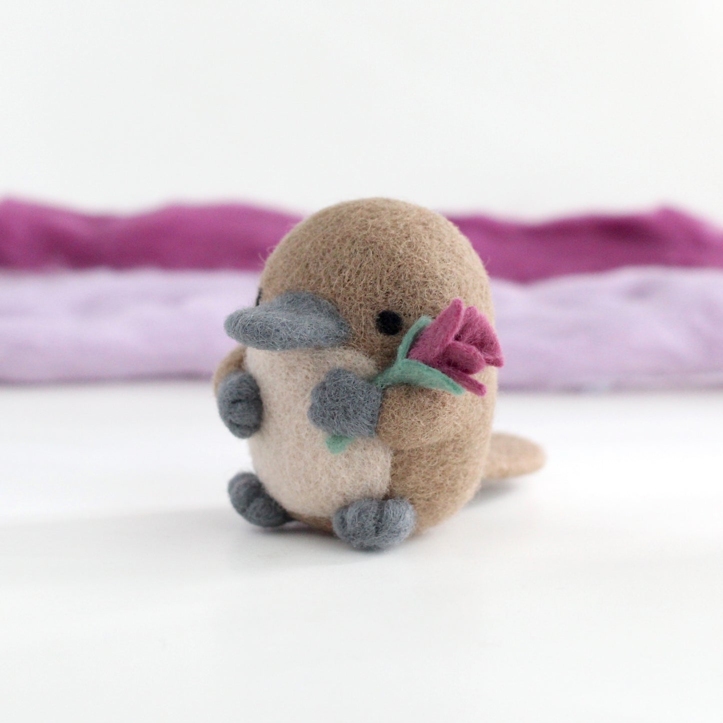 Needle Felted Platypus holding a Wildflower (Magenta)