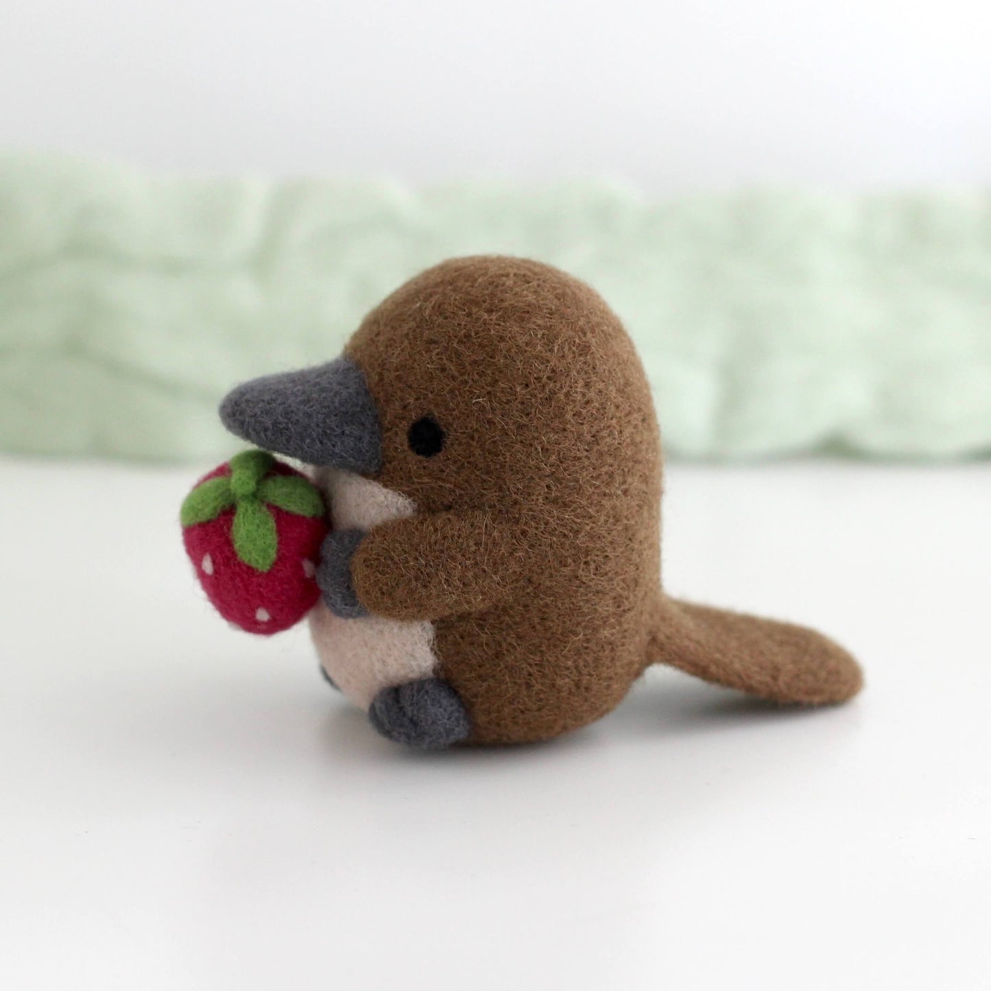 Needle Felted Platypus Holding Dark Red Strawberry