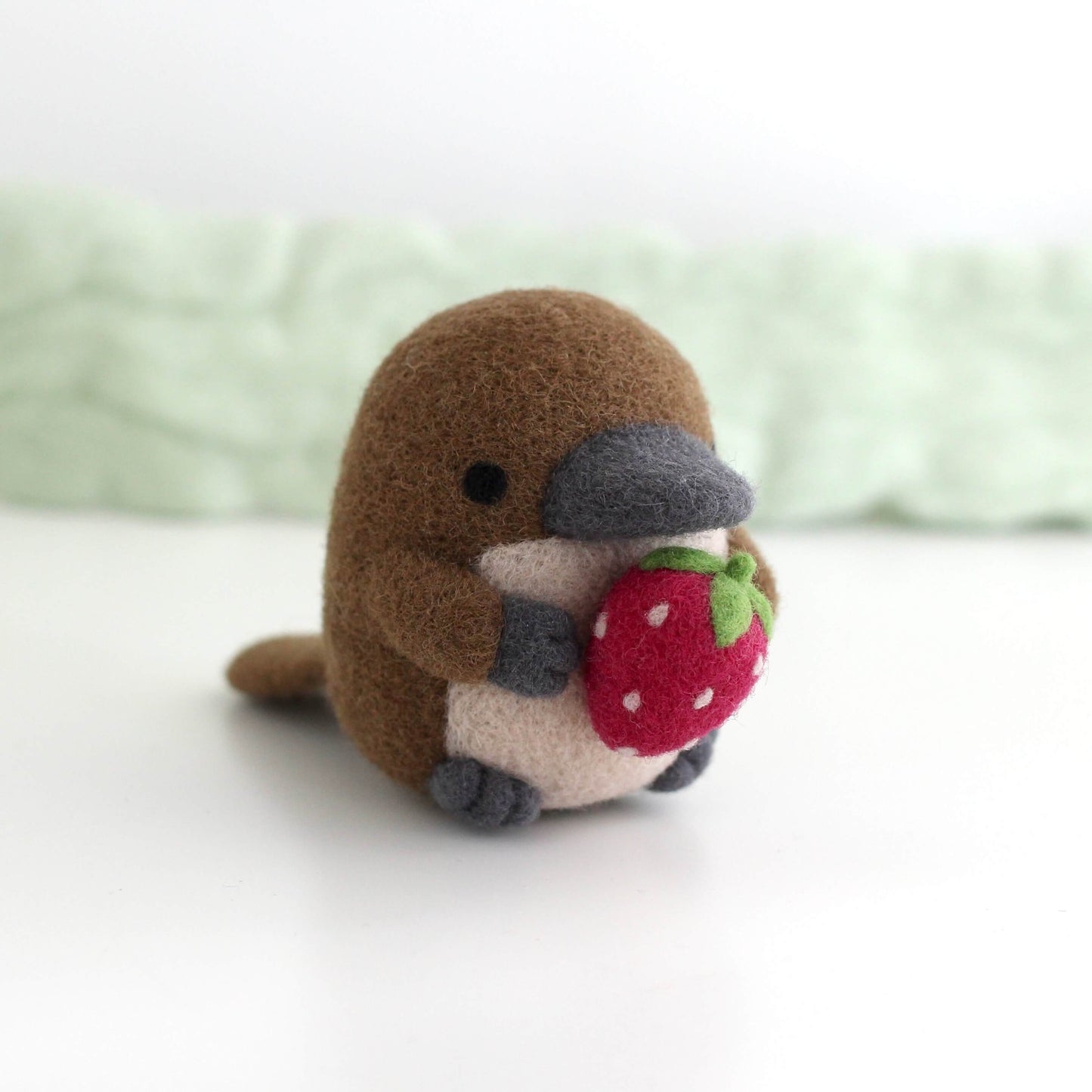 Needle Felted Platypus Holding Dark Red Strawberry