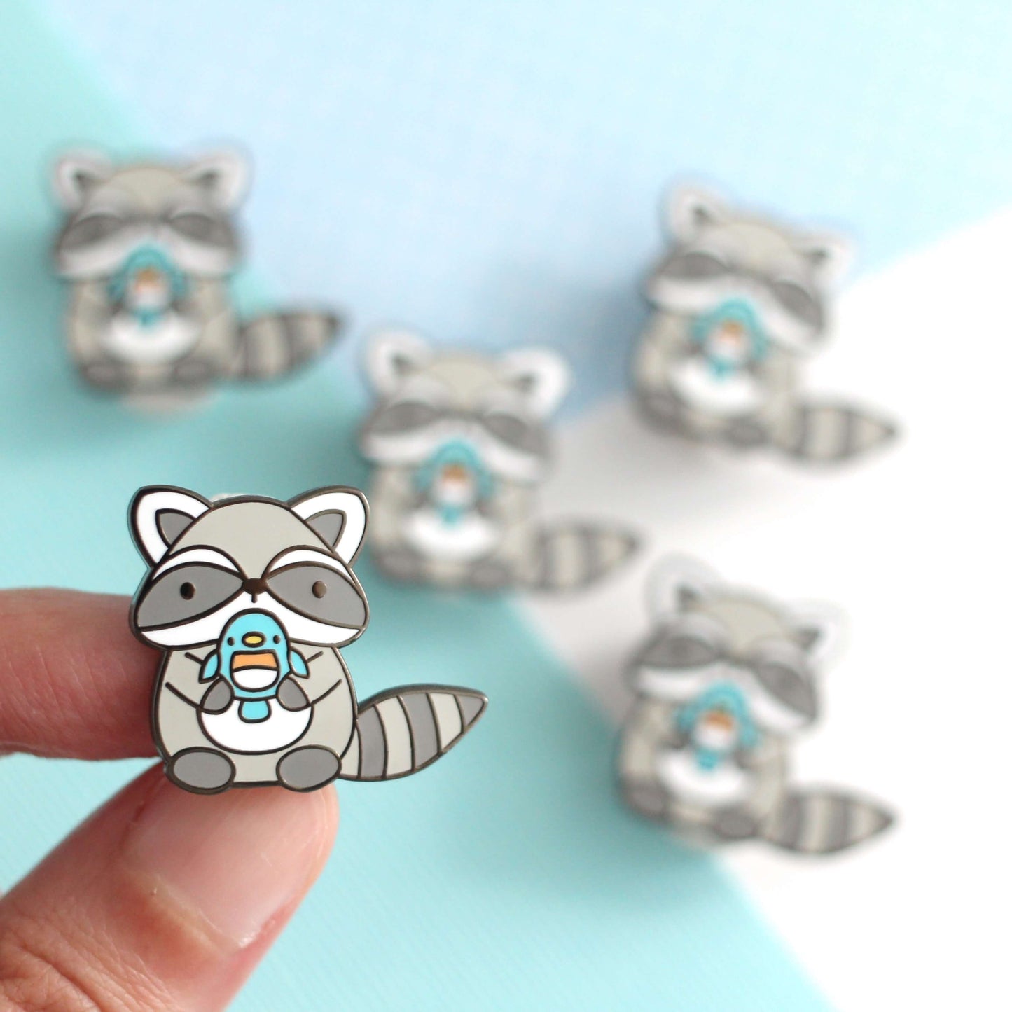 Raccoon holding Blue Bird Enamel Pin